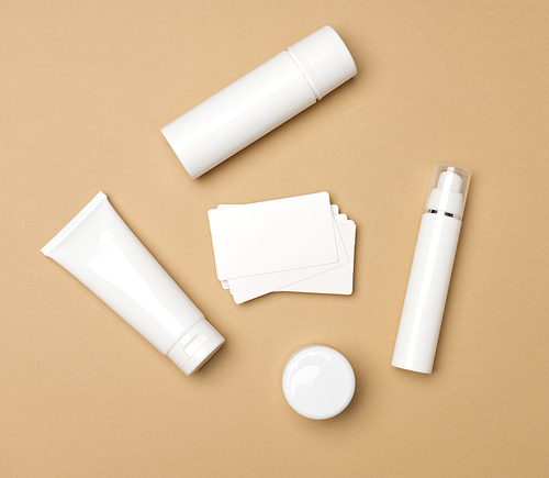 jar, bottle and empty white plastic tubes for cosmetics on a beige background. Packaging for cream, gel, serum, advertising and product promotion, mock up, top view