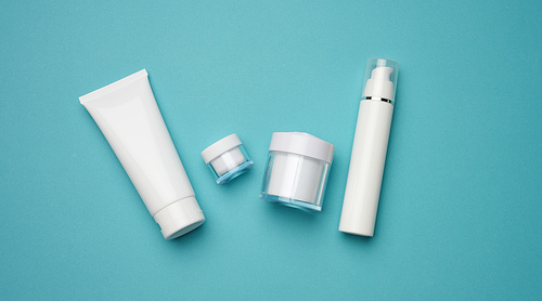 jar, bottle and empty white plastic tubes for cosmetics on a blue background. Packaging for cream, gel, serum, advertising and product promotion, mock up