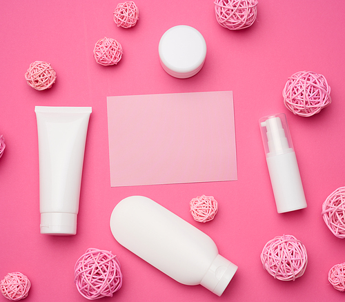 empty paper card and bottle and empty white plastic tubes for cosmetics on a pink background. Packaging for cream, gel, serum, advertising and product promotion, mock up