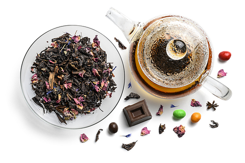 Black tea with natural flavors and a teapot. Top view on white background.