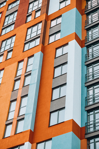 Modern building angle and windows. Multistory new multicolored apartment building. Stylish living block of flats. Parts of the facades of modern houses. Bright juicy colors in the construction of buildings.