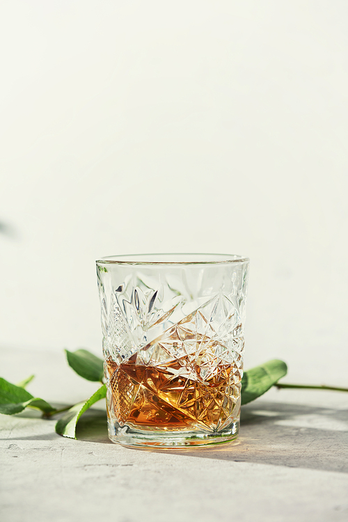 Whiskey with ice close up. Grey stone background