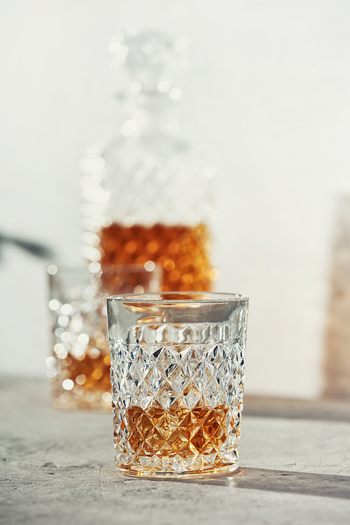 Whiskey with ice close up. Grey stone background