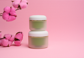 green jar for cosmetics on a pink background. Packaging for cream, gel, serum, advertising and product promotion, mock up