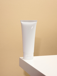 empty white plastic tubes for cosmetics on a white table. Packaging for cream, gel, serum, advertising and product promotion, mock up