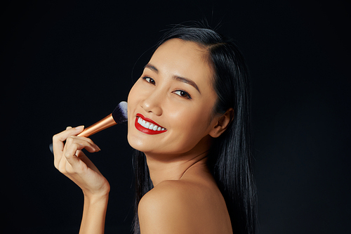 Portrait Of Beautiful Smiling Girl Applying Loose Blush With Cosmetic Brush.