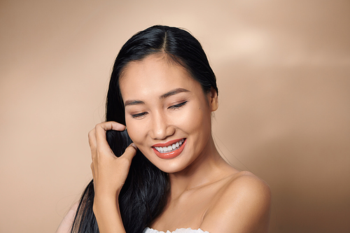 Beautiful sexy asian woman model posing on beige background