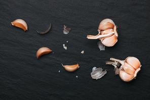Garlic Cloves and Garlic Bulb on black stone table.