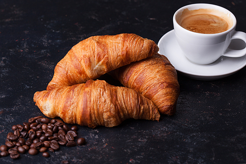 Breakfast with freshly baked croissants and cup of coffee. Golden crust.