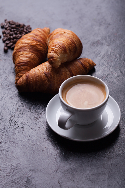 Breakfast with freshly baked croissants and cup of coffee. Golden crust.
