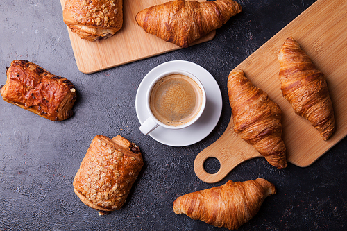 Assortment of pastries with coffee cup on wooden table background. French cuisine.