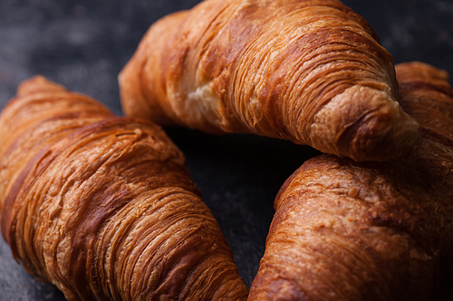 Tasty french croissants on a black wooden table. Great dessert.