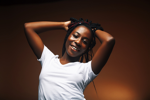 pretty young african american woman posing cheerful gesturing on brown background, lifestyle people concept close up