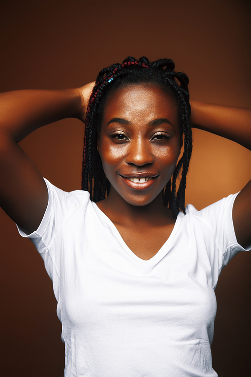 pretty young african american woman posing cheerful gesturing on brown background, lifestyle people concept close up