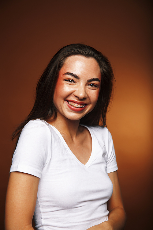 pretty girl happy posing: brunette on brown background, lifestyle people concept close up