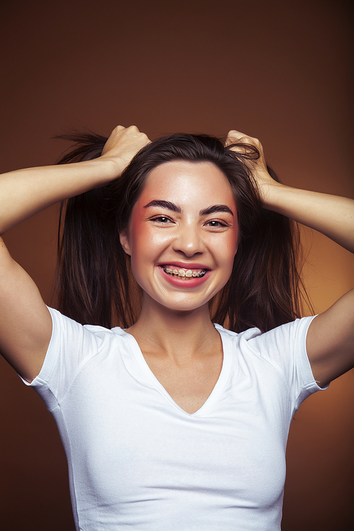 pretty girl happy posing: brunette on brown background, lifestyle people concept closeup
