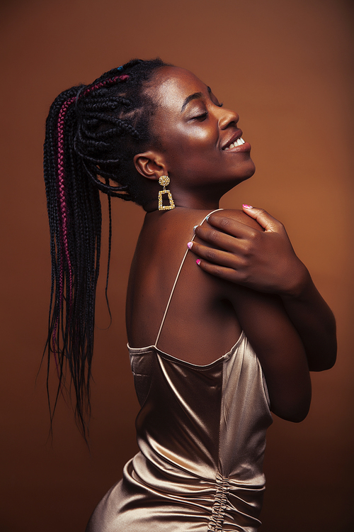 pretty young african american woman with braids posing cheerful gesturing on brown background, lifestyle people concept closeup