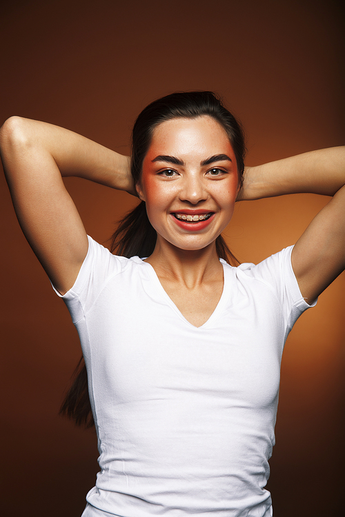 pretty girl happy posing: brunette on brown background, lifestyle people concept close up