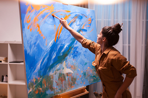 Painting with oil paint in art studio on large canvas. Modern artwork paint on canvas, creative, contemporary and successful fine art artist drawing masterpiece