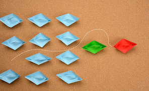 group of blue boats and one red one, which rushed forward. The concept of achieving goals by unique talented people, assertiveness and hard work. Business competition, top view