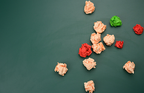 crumpled balls of paper on a green background, top view. Concept of finding innovative ideas, right solutions. Elimination of errors, unification around an idea, top view