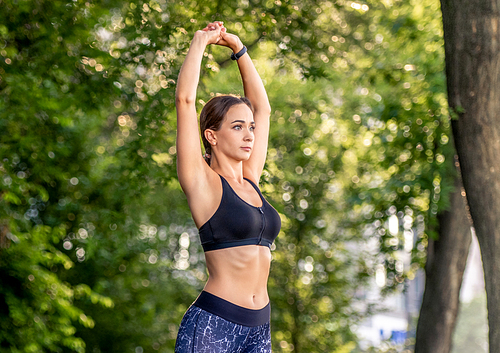 Sport girl doing yoga at nature in the morning. Young woman exercising and stretching outdoors