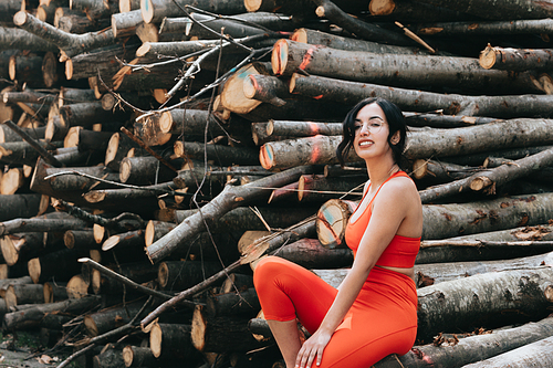Young woman in fitness clothes smiling to camera while sitting in a pile of trunks
