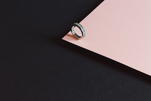 A diamond ring minimalistic shot over a pink and black background