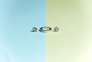 Minimalistic shot of a ring with earrings over a blue and yellow background