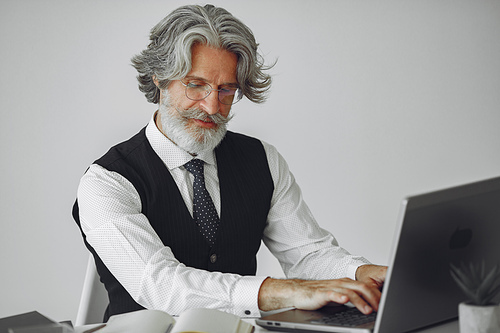 Elegant man in office. Businessman in white shirt. Man works with laptop.