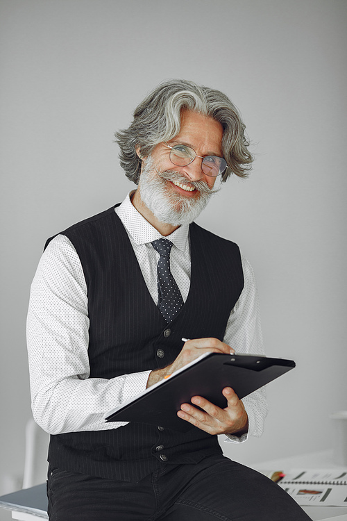 Elegant man in office. Businessman in white shirt. Man works with documents.