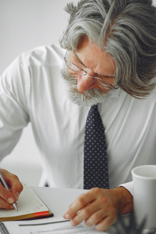 Elegant man in office. Businessman in white shirt. Man works with documents.