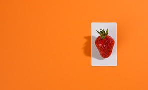 red ripe strawberries on an orange background, flat ay