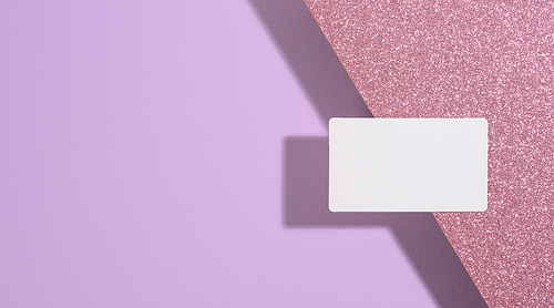 blank rectangular business card lies on a modern purple background sheets of paper with a shadow. Business template, flat lay