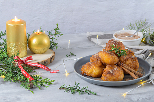 Traditional portuguese Christmas sweets Sonhos with sugar and cinnamon on kitchen countertop.