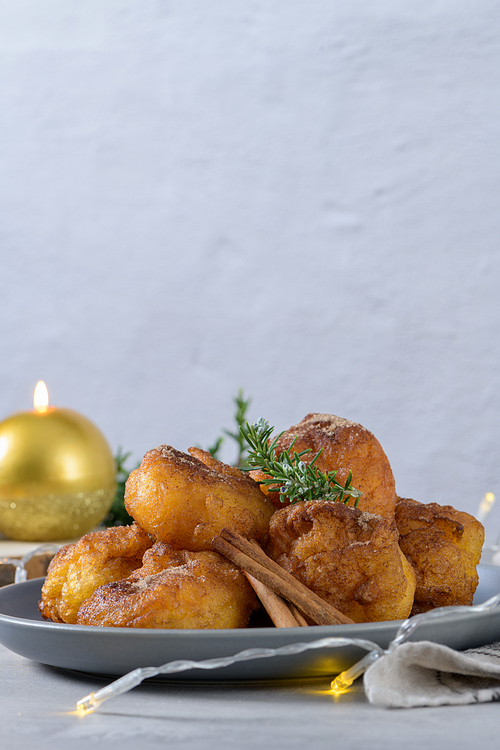 Traditional portuguese Christmas sweets Sonhos with sugar and cinnamon on kitchen countertop.