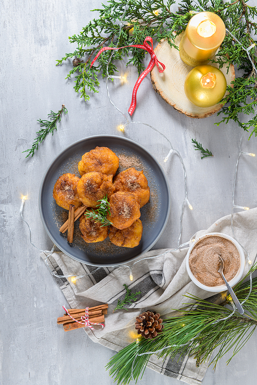 Traditional portuguese Christmas sweets Sonhos with sugar and cinnamon on kitchen countertop.