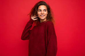 Shot of attractive happy smiling young woman wearing casual outfit standing isolated over colourful background with empty space looking to the side.