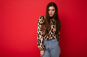 Close-up portrait of young nice-looking attractive lovely glamorous brunet woman wearing leopard blouse isolated on red color background with free space.