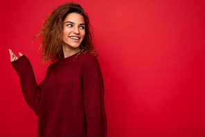Shot of attractive happy smiling young woman wearing casual outfit standing isolated over colourful background with empty space looking to the side.