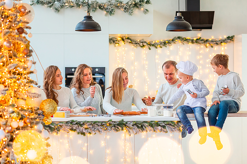 Big happy family making gingerbread, cutting cookies of gingerbread dough, having fun. Festive food, cooking process, family culinary, Christmas and New Year traditions concept. Christmas bakery.