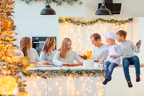 Big happy family making gingerbread, cutting cookies of gingerbread dough, having fun. Festive food, cooking process, family culinary, Christmas and New Year traditions concept. Christmas bakery.