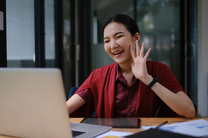 Portrait of a cheerful woman having video call on laptop computer at home.