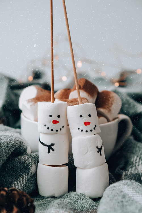 Two happy funny marshmallow snowmen. Marshmallow friends. Diy. Sweet treat for kids funny marshmallow snowman. Christmas winter holiday decoration. New year greeting card. Christmas lights. Cup of cacao