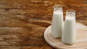 Fresh milk in two glass bottles. Wood rustic background. Healthy eating