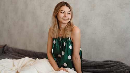 Beautiful smiling blonde in green pajamas. Good happy morning concept