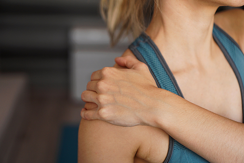 Closeup on fitness woman having pain in shoulder. Pain after home workout