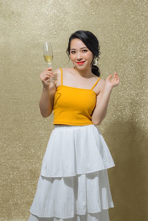 One young and beautiful woman dancing with glass of champagne and smiling. Party concept