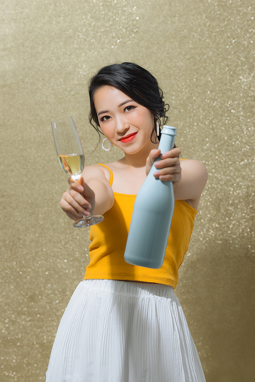 One young and beautiful woman dancing with glass of champagne and smiling. Party concept