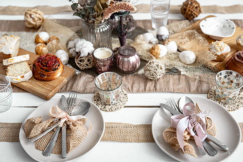 a festive table with beautiful dishes, decorative items and pastries. food table setting design idea.